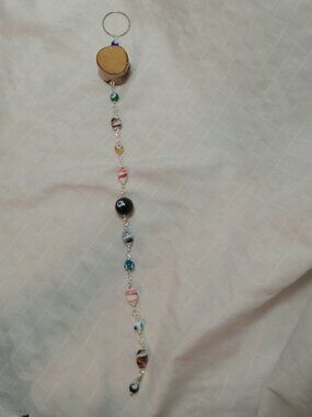 Handmade hanging decoration featuring handcrafted glass beads & wooden base